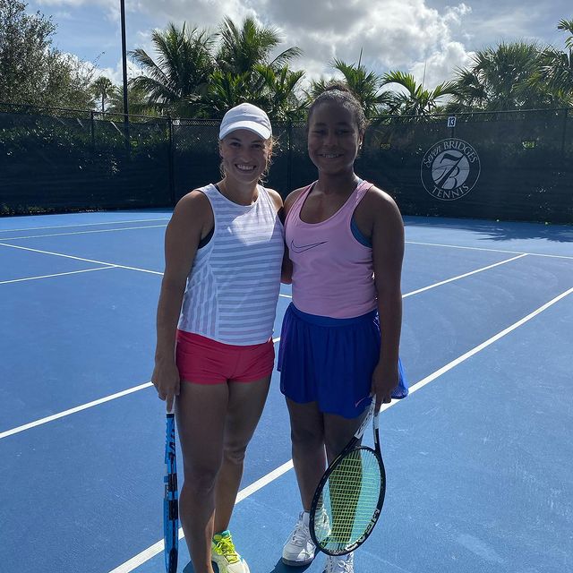 Milan Tyson in tennis court wearing a pink sleeveless and blue skirt